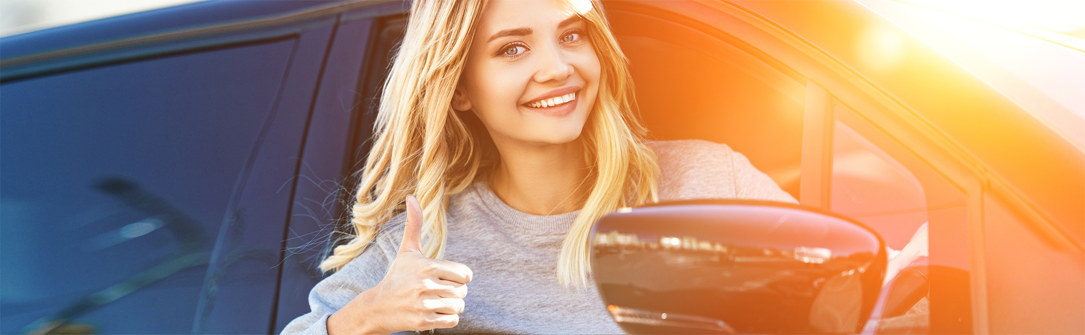 Woman in car. Click her to apply now for an auto loan.