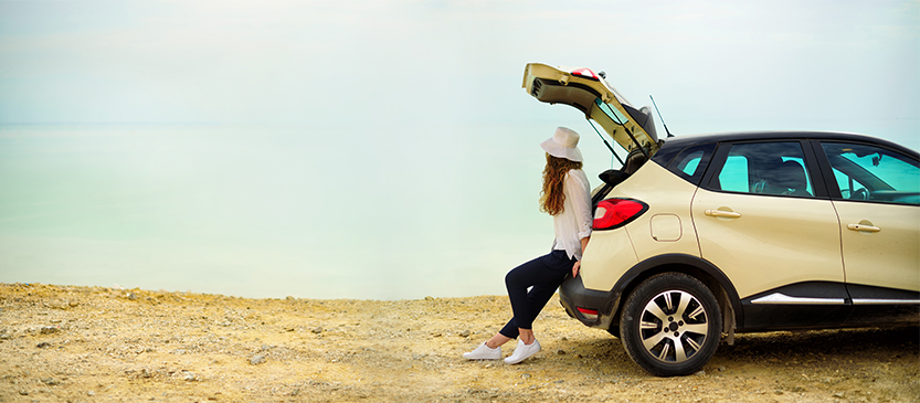 Girl leaning against a new car. Click her to apply for auto loan. 