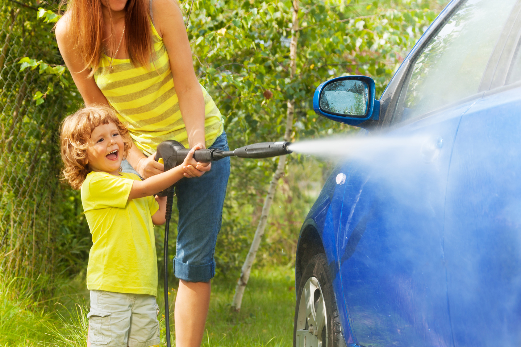 Mother and son washing a car