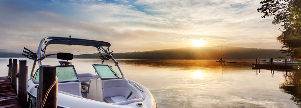 Boat tied to dock at sunset
